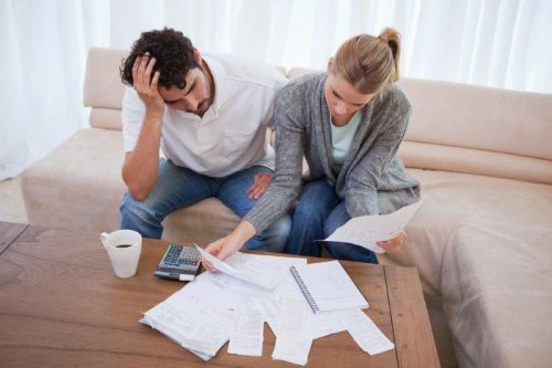 Couplle d'emprunteurs décourageé devant les factures de frais pour l'achat d'une maison