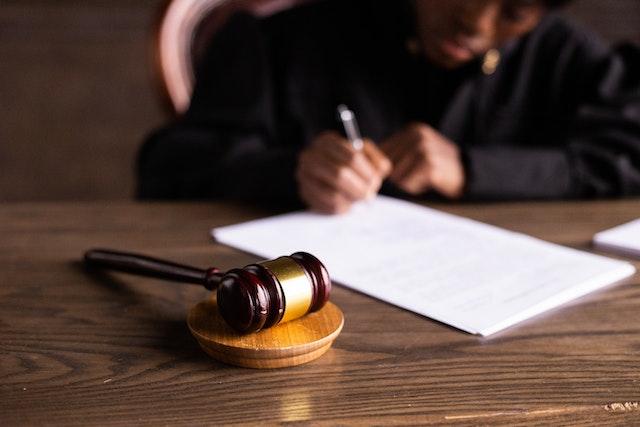 Maillet devant un juge signant un document de recours hypothécaire