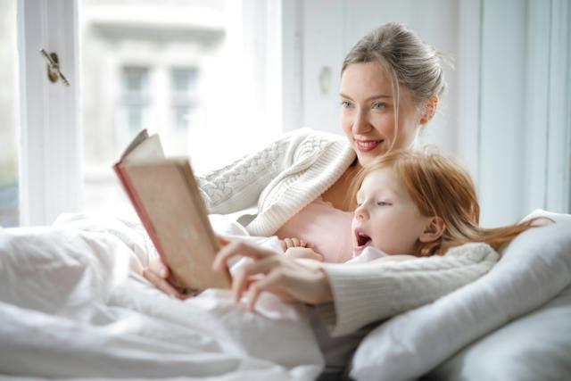 Maman et fille lisant une histoire au lit