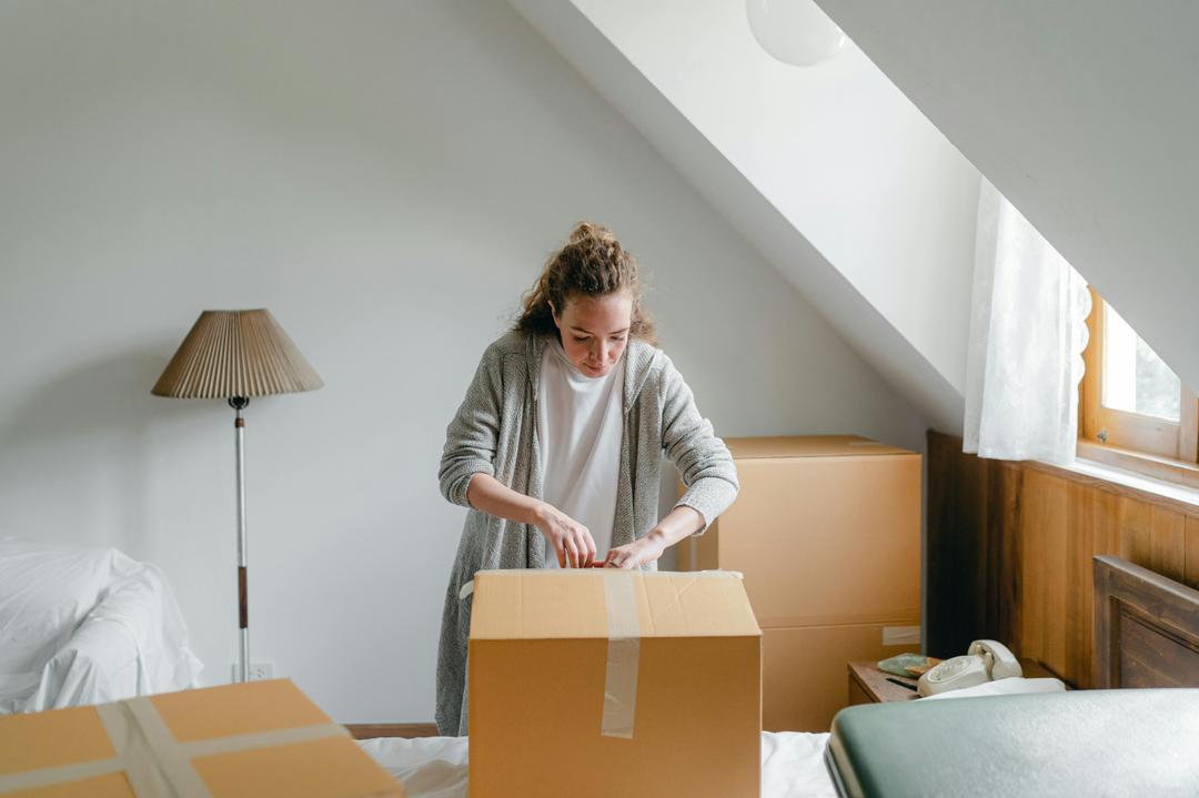 Femme qui emballe des objets dans des boites