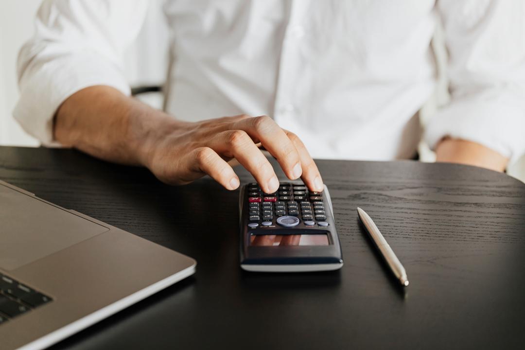 Homme calculant son taux hypothécaire mixte sur une calculatrice