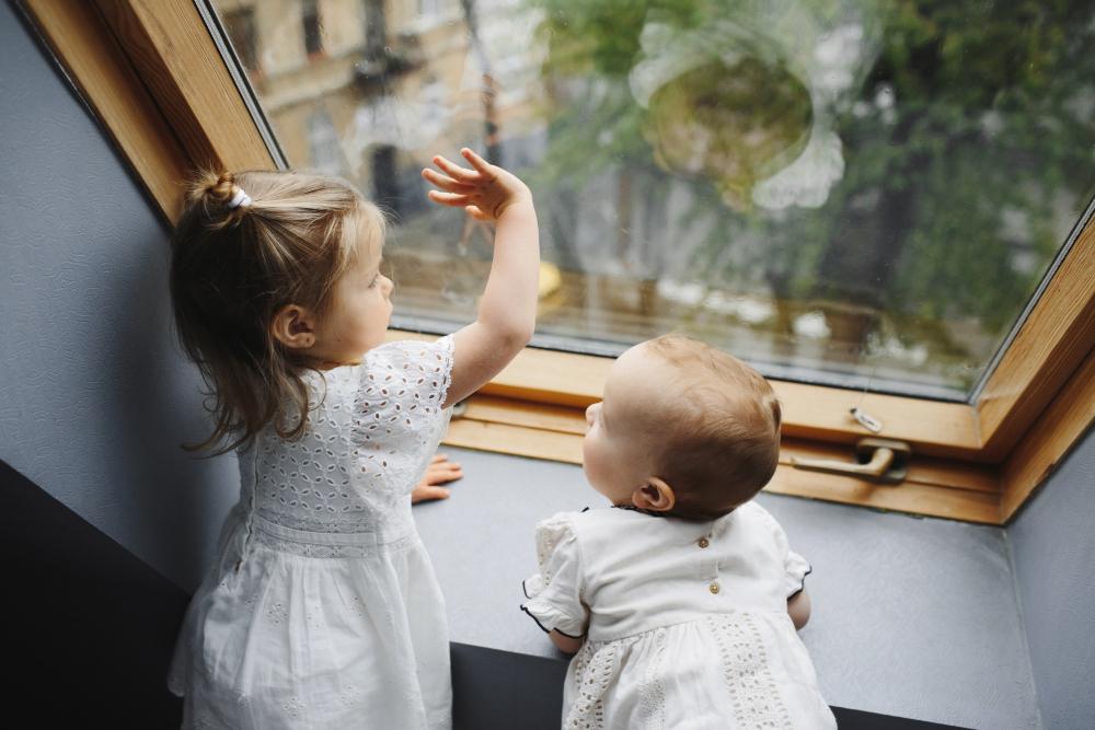 Bébé et bambin devant une fenêtre non sécurisée