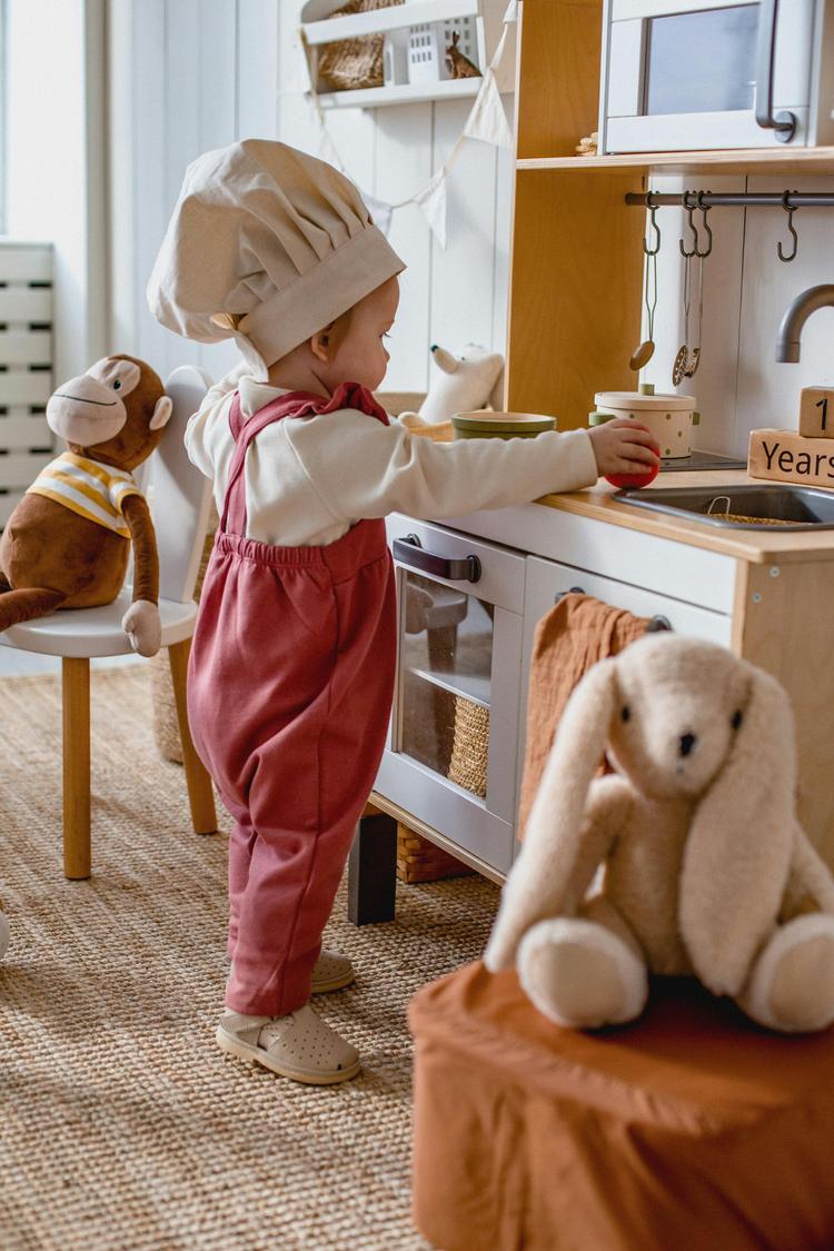 Une fillette joue dans une cuisine jouet 