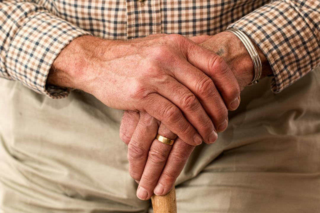 Mains d'un homme âgé tenant une canne