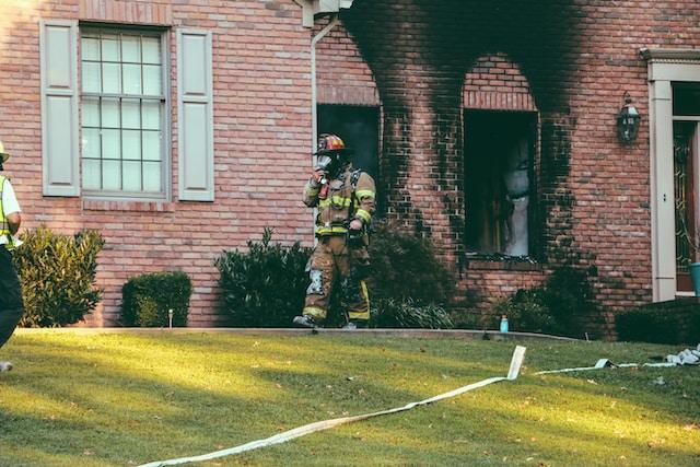 Pompier sortant d'une maison après avoir éteint l'incendie