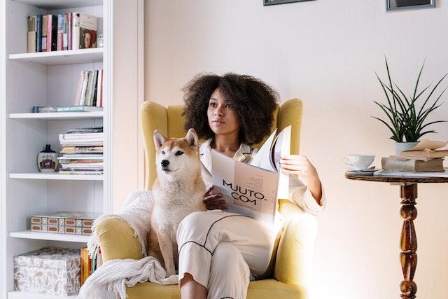Femme et son chien sur un fauteuil jaune d’un coin lecture