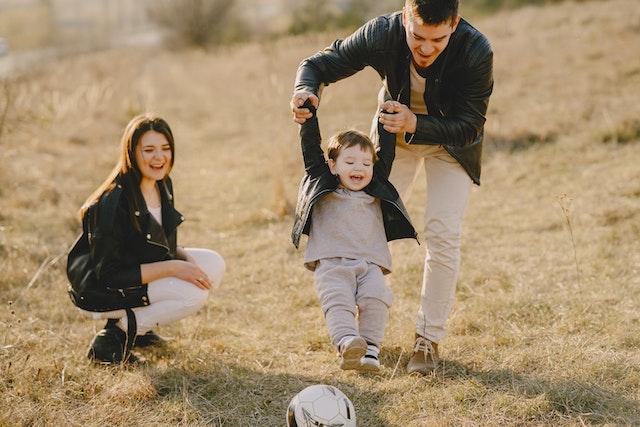 Famille heureuse avec un jeune enfant jouant avec un ballon