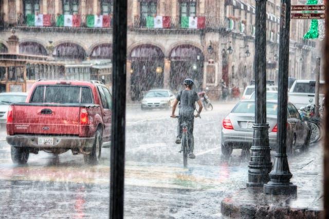 Vélo et voitures sous une pluie diluvienne