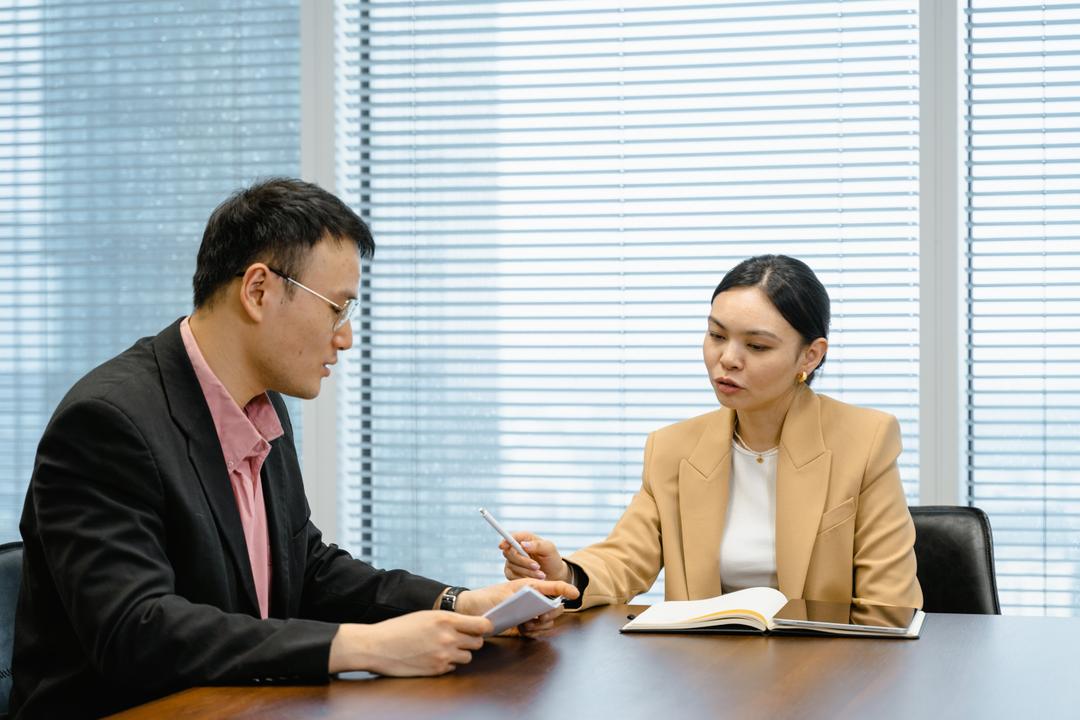 Two people in a office with documents