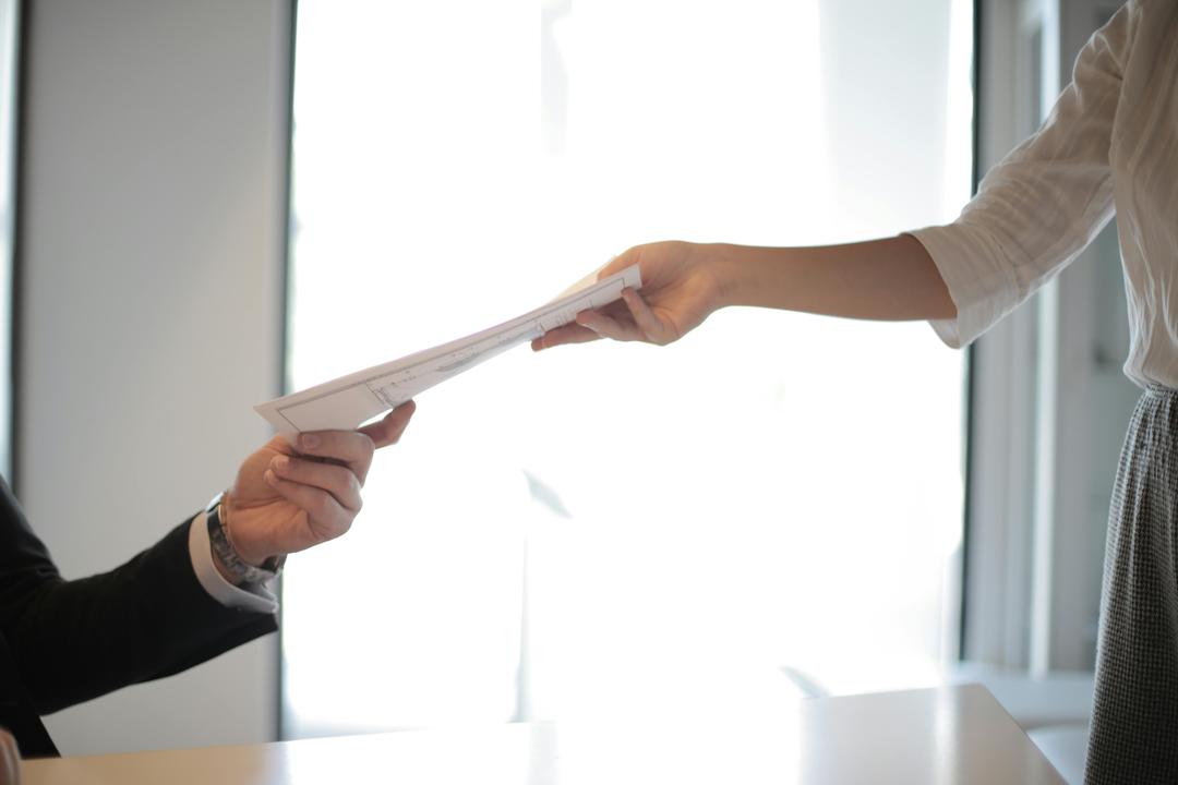 deux personnes échangeant un document