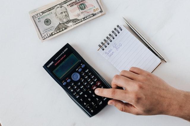 Someone using a calculator to count money