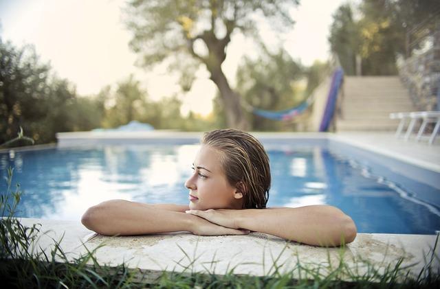 Femme bras croisés sur le bord d’une piscine creusée