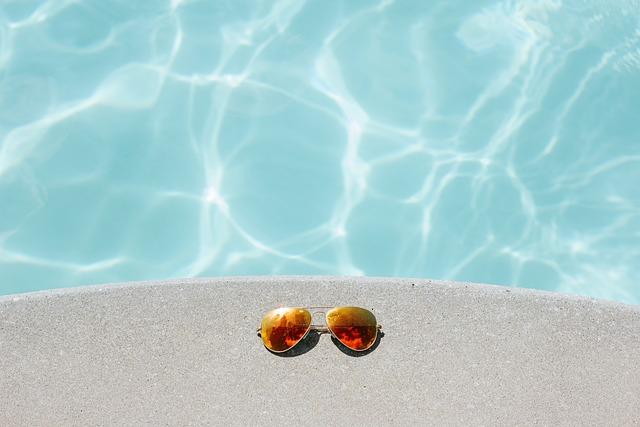 Lunettes de soleil à côté d’une piscine creusée