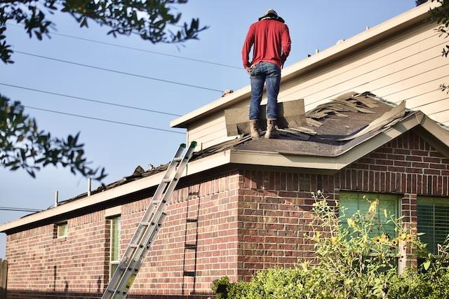Homme debout sur un toit en réfection