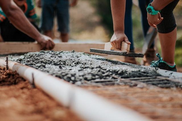 Personnes construisant les fondations d’une maison