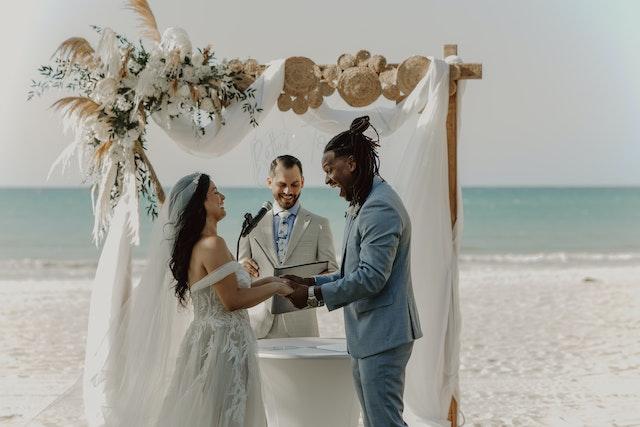 Couple se mariant sur une plage devant le célébrant