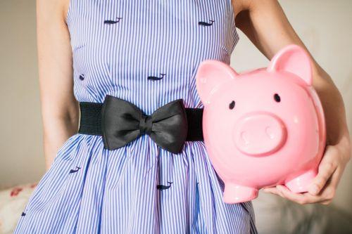 Woman holding a piggy bank to pay her condo fees