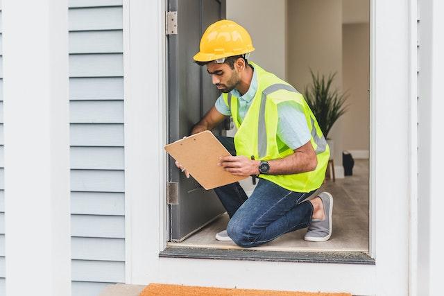 A building inspector looking at a door frame