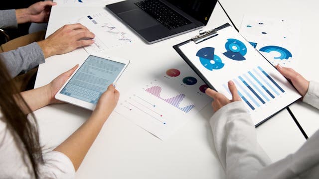 Personnes analysant des statistiques pour produire un rapport