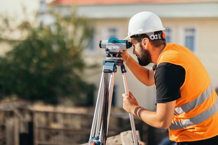 Technicien en arpentage regardant dans un théodolite