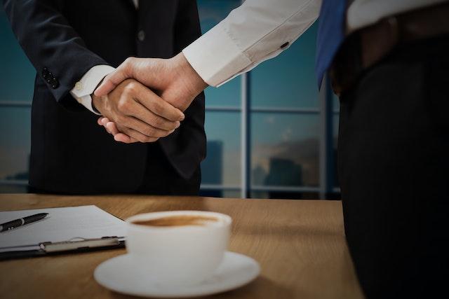 Emprunteur serrant la main d'un prêteur après avoir transféré son hypothèque