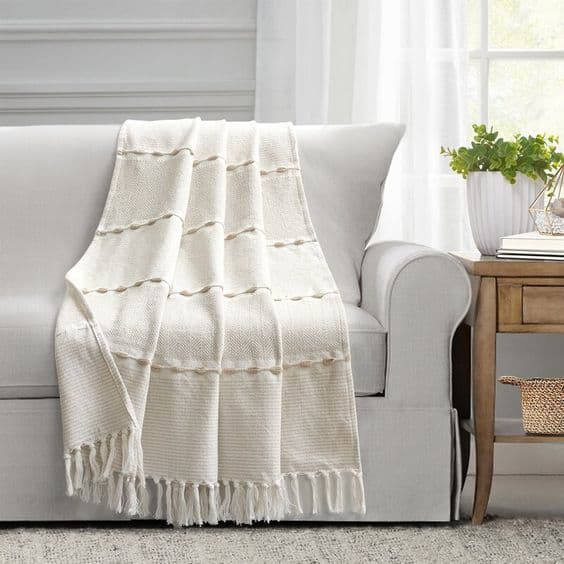 Sofa gris pâle avec un jeté blanche légère