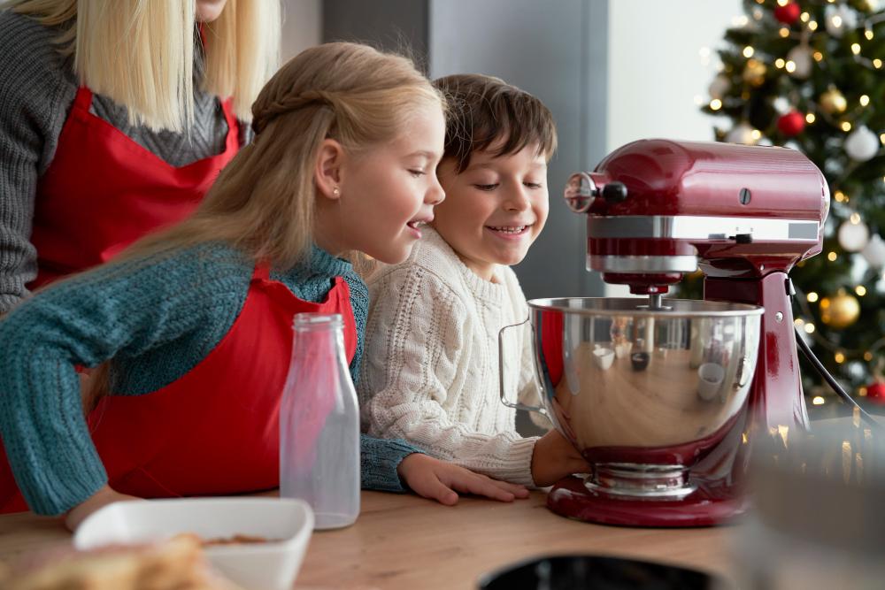 Enfant faisant des biscuits de Noël dans un batteur sur socle