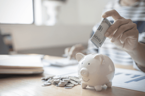 Person putting money in a piggy bank