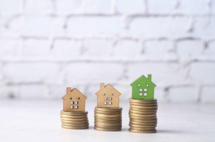 Small houses on piles of money