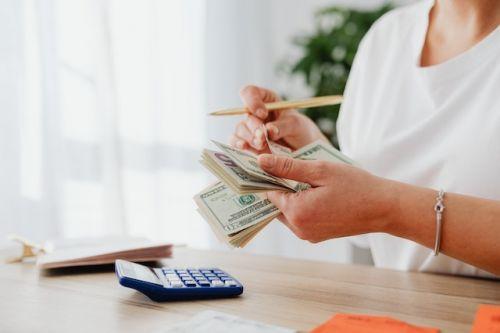 Woman counting money to buy a share of a property
