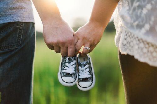 A couple holding baby shoes