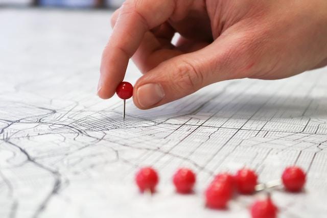 Main plaçant un indicateur sur la cartographie d’une ville