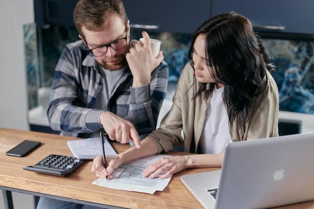 Couple regardant leurs finances avant de faire une consolidation de dettes
