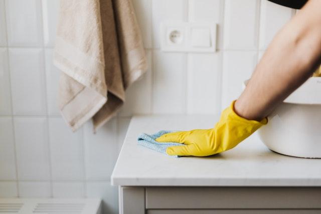 Personnes nettoyant la surface d’un comptoir de salle de bain