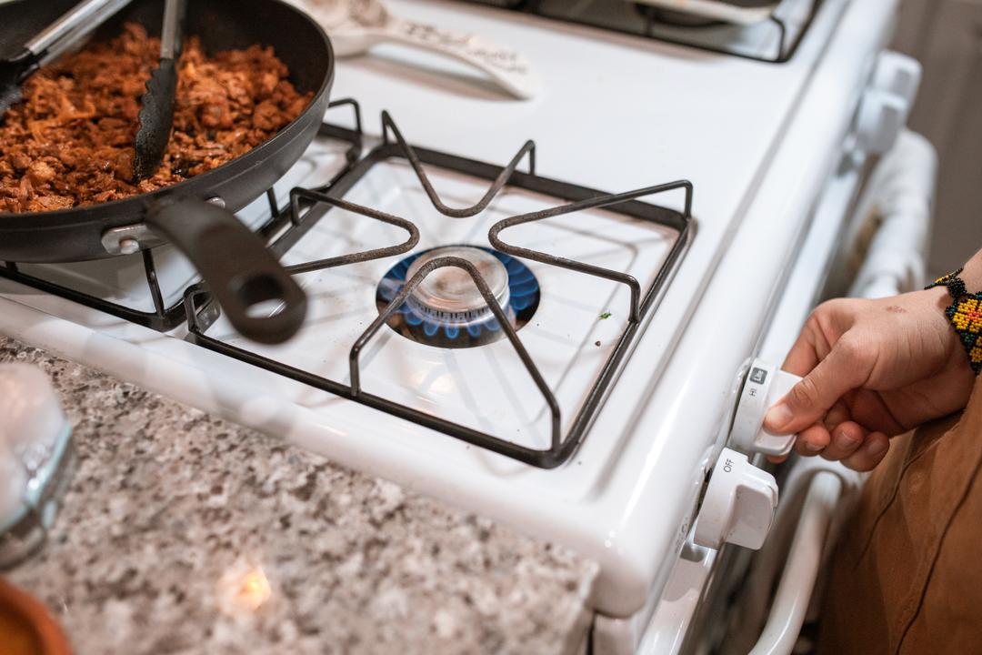 Un plat se faisant cuisiner sur une cuisinière à gaz
