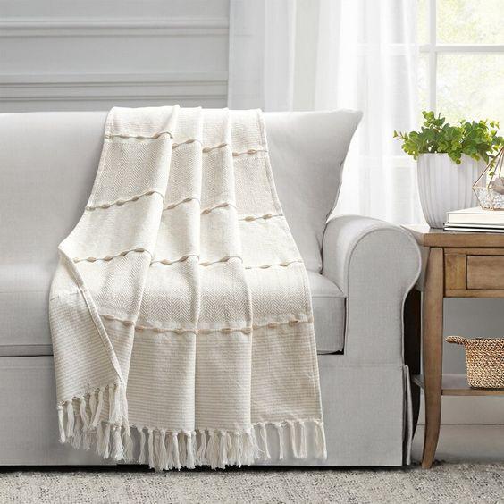 Sofa gris pâle avec un jeté blanche légère