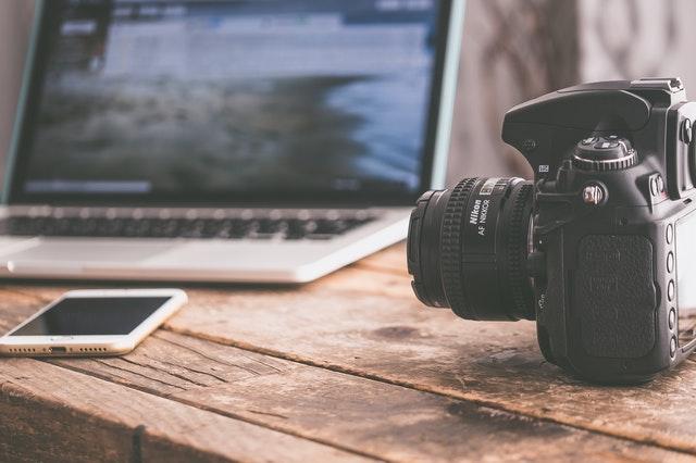 Appareil photo posé sur une table à côté d'un ordinateur