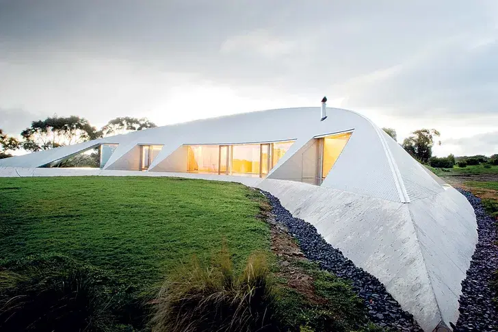 Vue rapprochée de l'extérieur d'une maison futuriste en forme de croissant