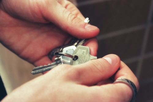 Une main tenant des clés lors d'une visite d'un bien immobilier