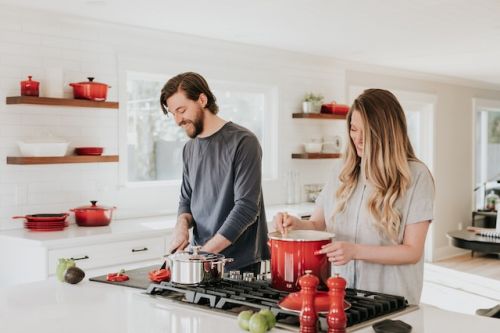 Jeune couple cuisinant dans leur nouvelle maison jumelée