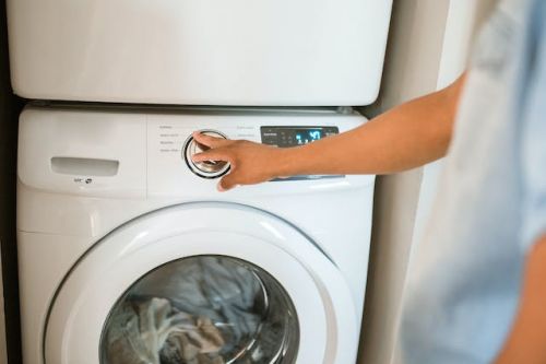 Homme appuyant sur le bouton d’une machine à laver