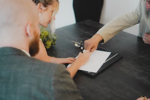 Couple signant un contrat de vie commune devant un notaire