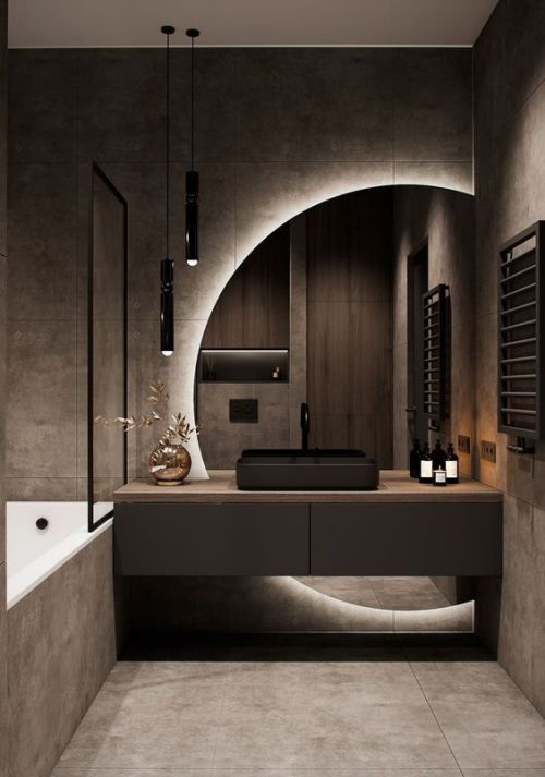 Salle de bain sombre avec un grand miroir rond