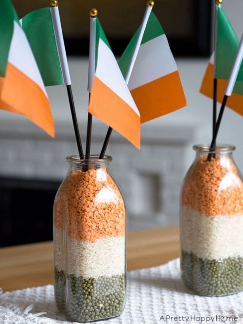 Drapeaux irlandais dans des vases remplis d'aliments oranges, blancs et verts