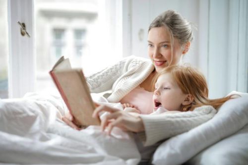 Maman et fille lisant une histoire au lit