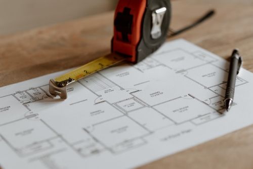 Plan d’une maison, crayon et ruban à mesurer