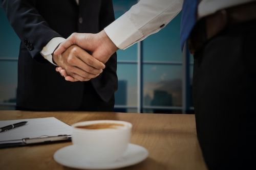 Emprunteur serrant la main d'un prêteur après avoir transféré son hypothèque